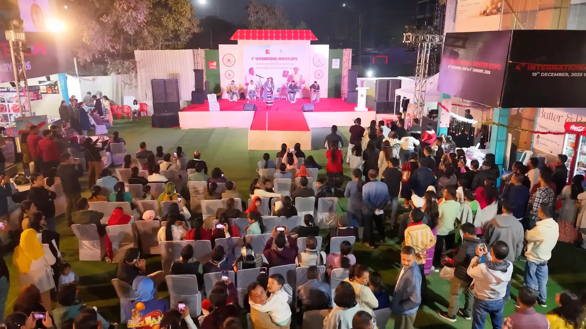 Large evening crowd seated in front of the expo main stage